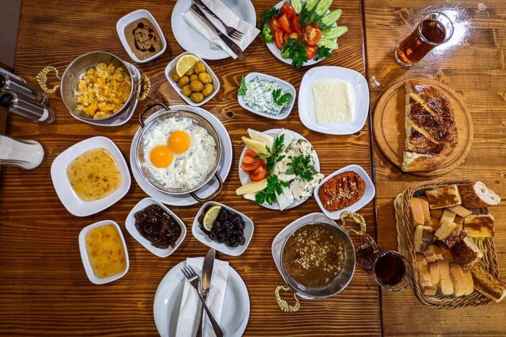 Spread of Turkish breakfast dishes including cheeses, olives, eggs, and fresh bread.