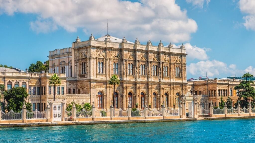 Dolmabahçe Palace's white ornate facade along the Bosphorus waterfront in Istanbul.